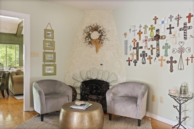 sitting room featuring a fireplace, lofted ceiling, and hardwood / wood-style flooring