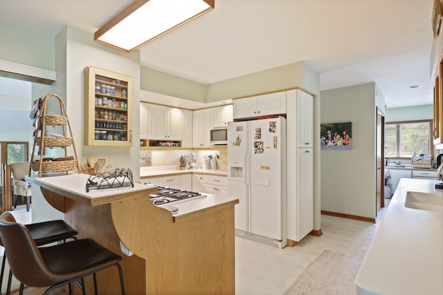 kitchen with a breakfast bar, a center island, white cabinets, sink, and stainless steel appliances