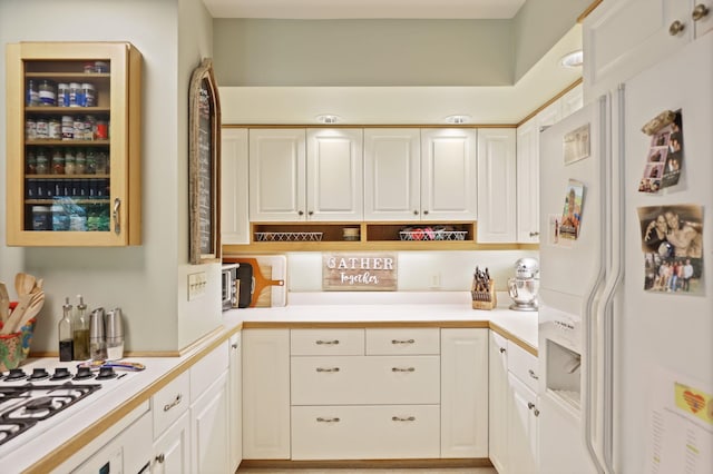 kitchen featuring white cabinetry and white appliances