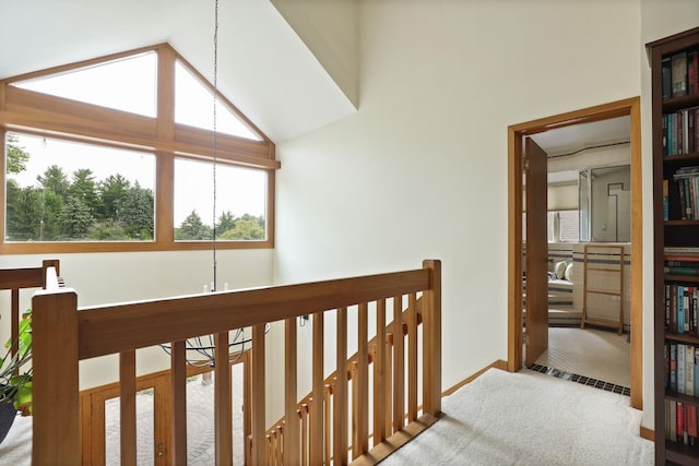 hallway with carpet flooring, an inviting chandelier, and lofted ceiling