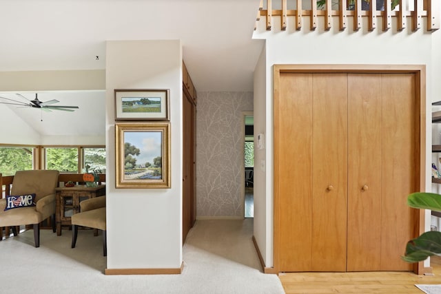 hall featuring lofted ceiling and light wood-type flooring