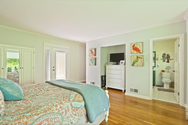 bedroom featuring hardwood / wood-style flooring, crown molding, access to outside, and ensuite bath