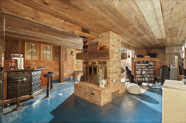 living room with wooden ceiling, a brick fireplace, brick wall, wood walls, and indoor bar