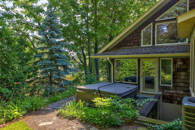 exterior space with central AC unit and a hot tub