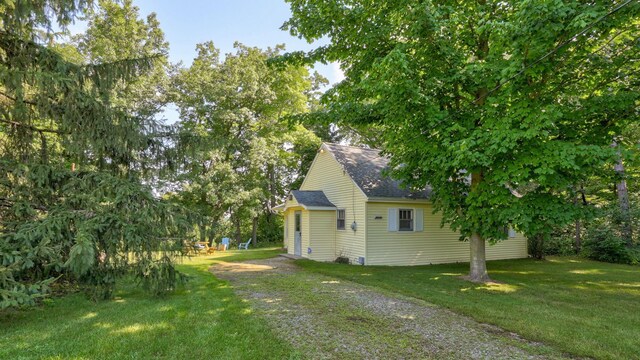 9300 Ormes Rd, Vassar, MI 49768 - view of side of property with a shingled roof and a yard