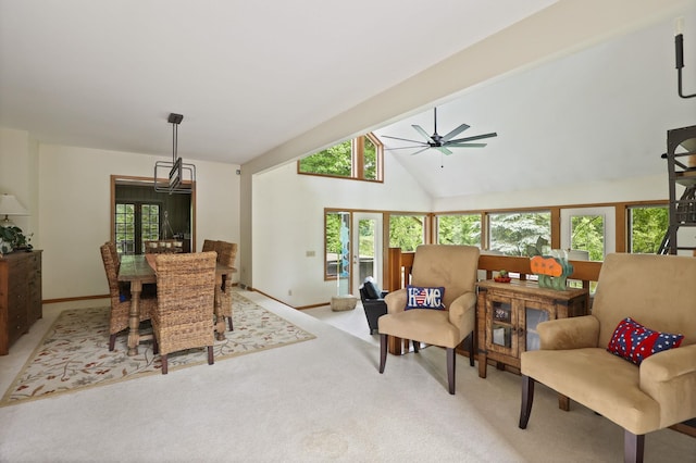 carpeted dining space featuring a wealth of natural light, beamed ceiling, high vaulted ceiling, and ceiling fan