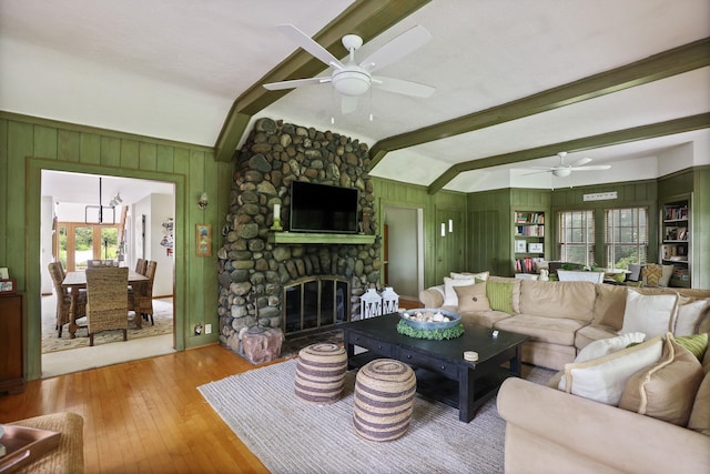 living room with a fireplace, wood-type flooring, vaulted ceiling with beams, and plenty of natural light