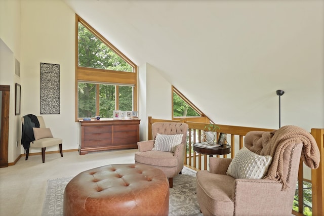 sitting room with plenty of natural light, light carpet, and high vaulted ceiling