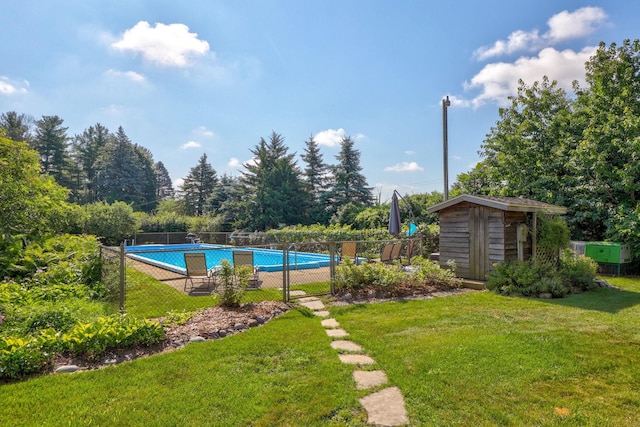 view of pool with a storage unit and a yard