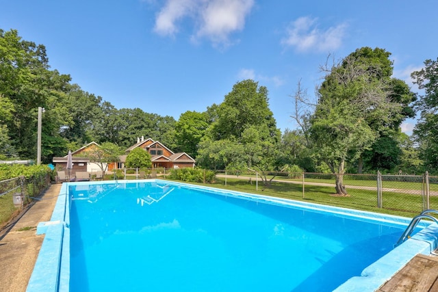 view of swimming pool with a lawn