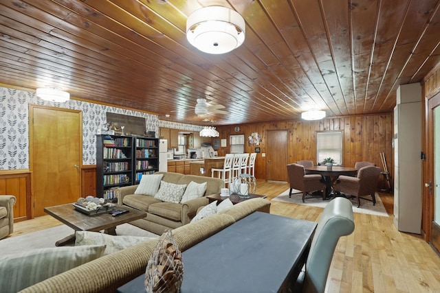 living room with wooden walls, ceiling fan, wood ceiling, and light wood-type flooring