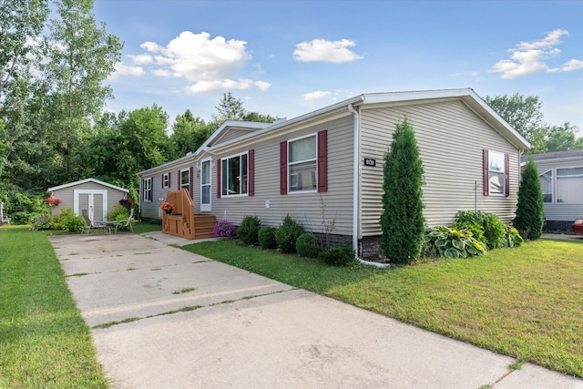 manufactured / mobile home featuring a front yard and a shed