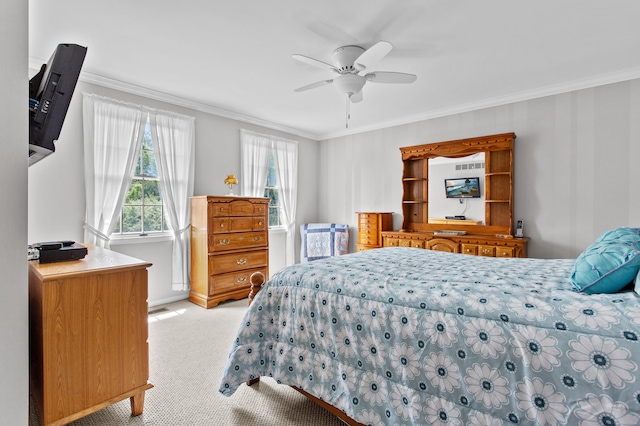 carpeted bedroom with ceiling fan and ornamental molding