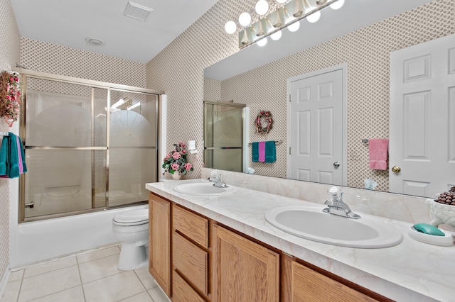 full bathroom with tile patterned floors, vanity, enclosed tub / shower combo, and toilet