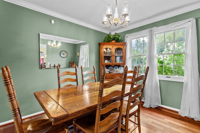 dining room featuring a notable chandelier, light wood-type flooring, and ornamental molding