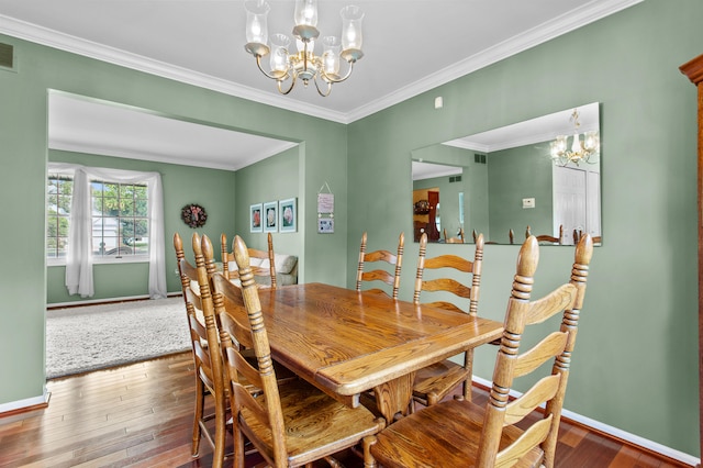 dining area with ornamental molding, dark hardwood / wood-style floors, and an inviting chandelier