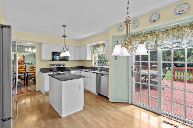 kitchen with white cabinetry, a center island, light hardwood / wood-style floors, and appliances with stainless steel finishes