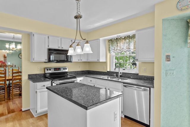 kitchen featuring white cabinets, sink, light hardwood / wood-style floors, appliances with stainless steel finishes, and a kitchen island