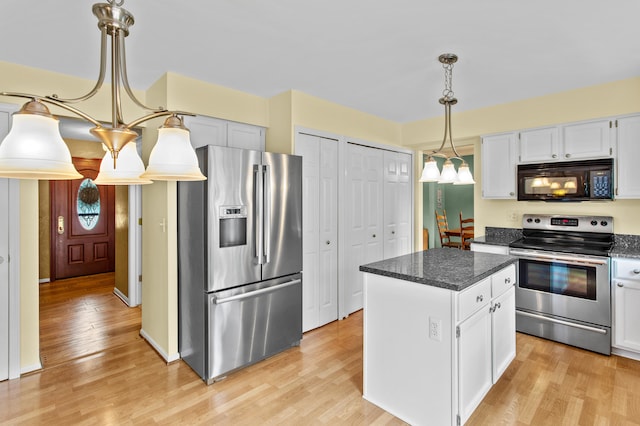 kitchen with a kitchen island, white cabinetry, stainless steel appliances, and light hardwood / wood-style flooring