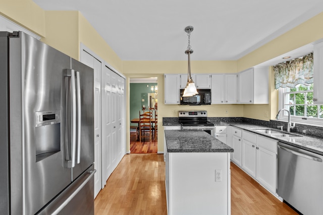 kitchen with sink, a kitchen island, light hardwood / wood-style flooring, white cabinets, and appliances with stainless steel finishes