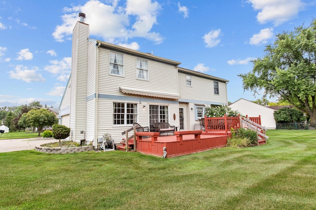 back of house with a lawn and a deck