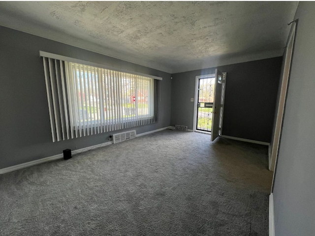 carpeted spare room featuring a textured ceiling