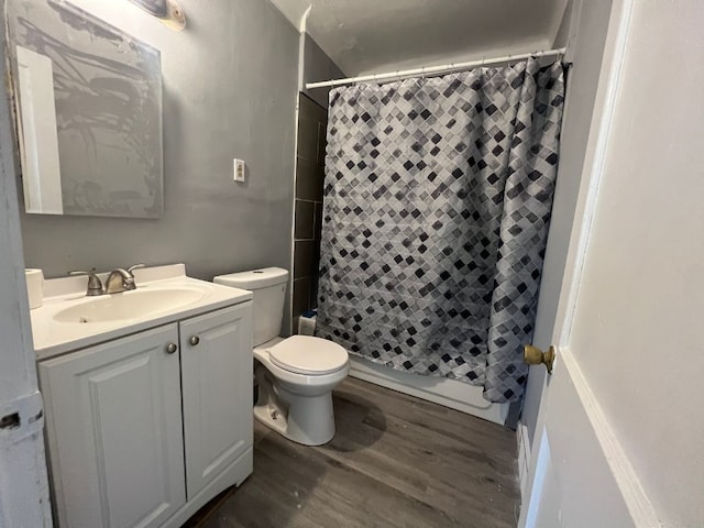 full bathroom featuring hardwood / wood-style floors, vanity, shower / bath combo, and toilet