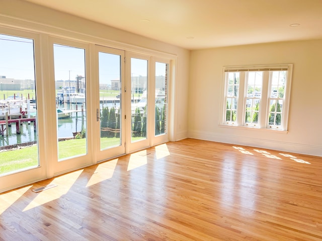 488 Parkview Dr, Detroit, MI 48214 - spare room featuring a water view, light wood finished floors, and baseboards