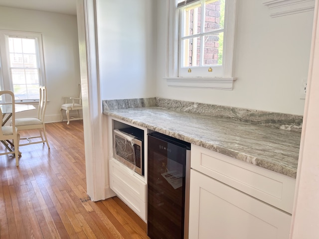 488 Parkview Dr, Detroit, MI 48214 - kitchen with beverage cooler, light wood-type flooring, stainless steel microwave, and plenty of natural light