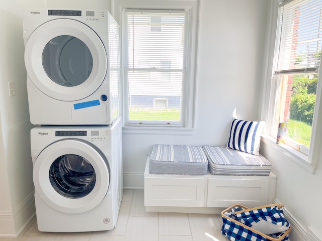 laundry area featuring stacked washer and dryer and light tile patterned flooring