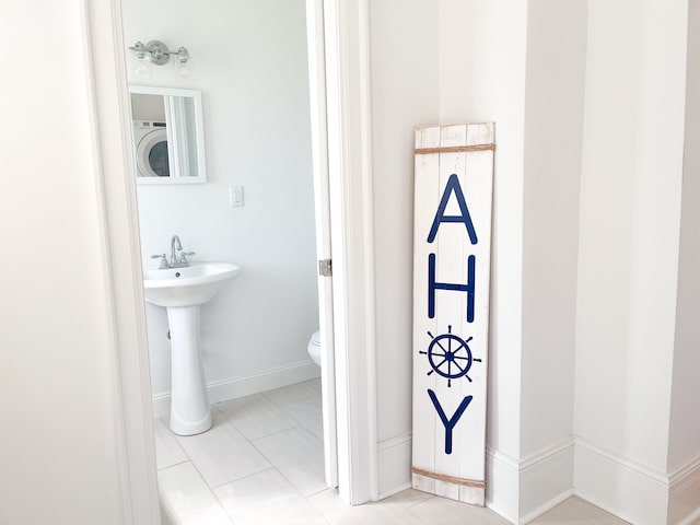 bathroom with toilet and washer / clothes dryer