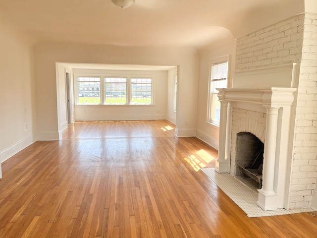 unfurnished living room with a fireplace and light hardwood / wood-style flooring