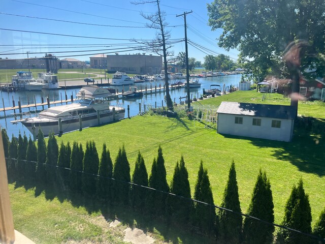 488 Parkview Dr, Detroit, MI 48214 - view of grassy yard with a boat dock and a water view