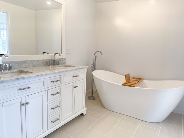 bathroom featuring tile patterned flooring, vanity, and a bath