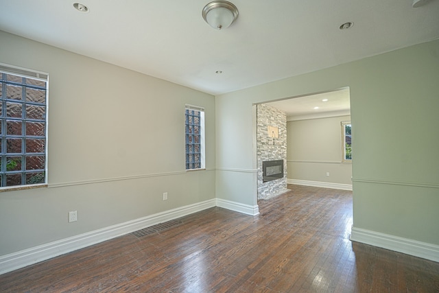 unfurnished living room featuring a fireplace and dark wood-type flooring