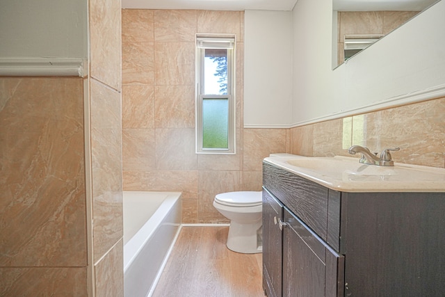 bathroom featuring vanity, a bath, wood-type flooring, tile walls, and toilet