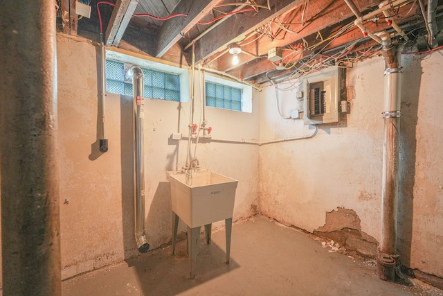 basement featuring electric panel and sink