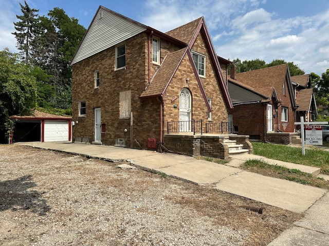 view of front of house with a garage and an outbuilding