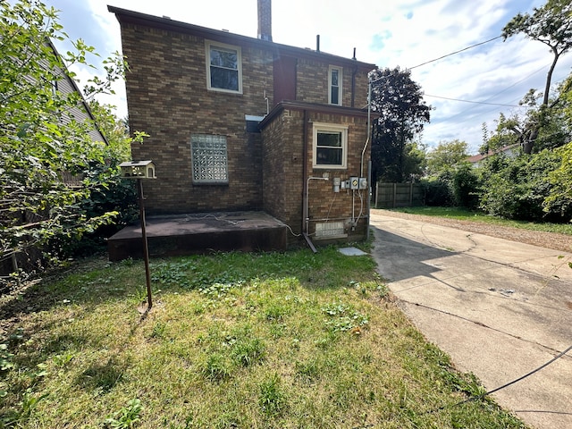 rear view of property featuring a lawn