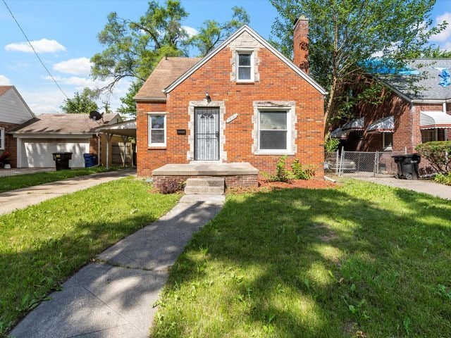 view of front facade with a front yard and a carport