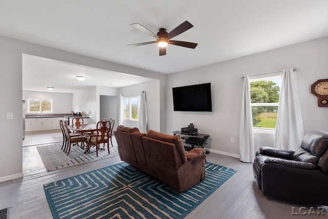 living room with a wealth of natural light, ceiling fan, and light hardwood / wood-style floors