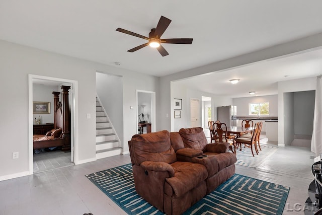 living room featuring hardwood / wood-style flooring, ceiling fan, and sink