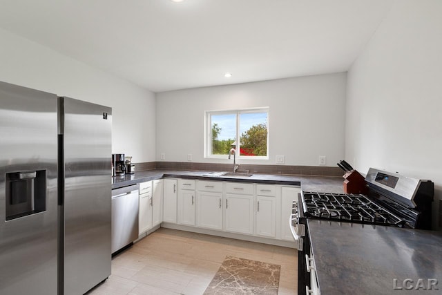 kitchen featuring appliances with stainless steel finishes, white cabinetry, and sink