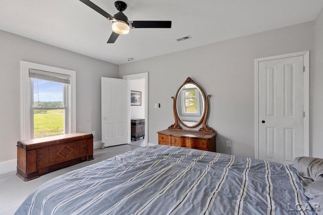 bedroom featuring ceiling fan, concrete flooring, and a closet