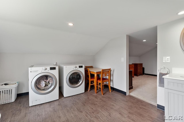 clothes washing area with wood-type flooring and independent washer and dryer