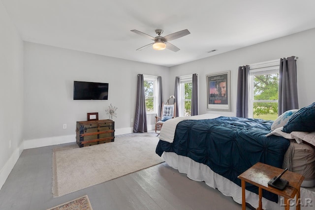 bedroom featuring hardwood / wood-style flooring, multiple windows, and ceiling fan