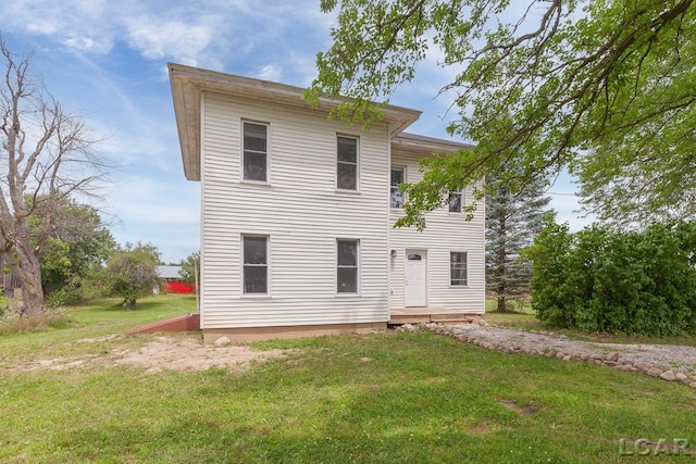 rear view of property featuring a yard