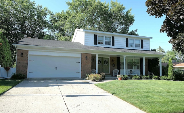 front of property featuring a porch, a garage, and a front lawn