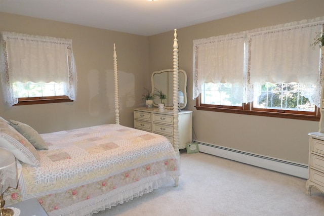 bedroom featuring light colored carpet, baseboard heating, and multiple windows