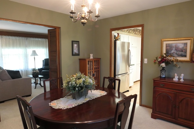 dining space featuring a chandelier and light colored carpet